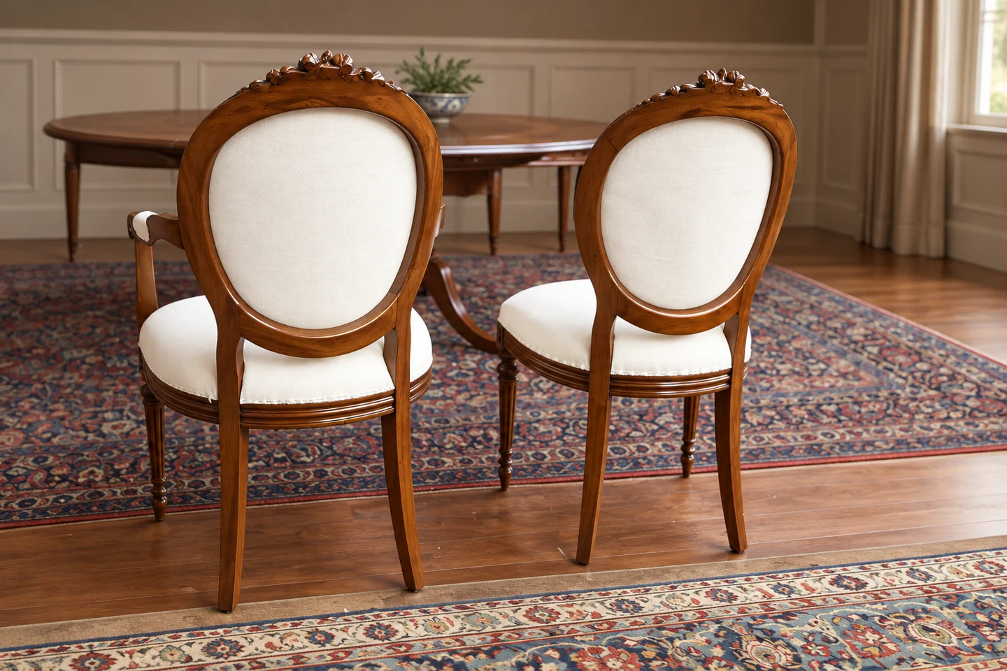 A pair of dining chairs with newly upholstered pale seats.